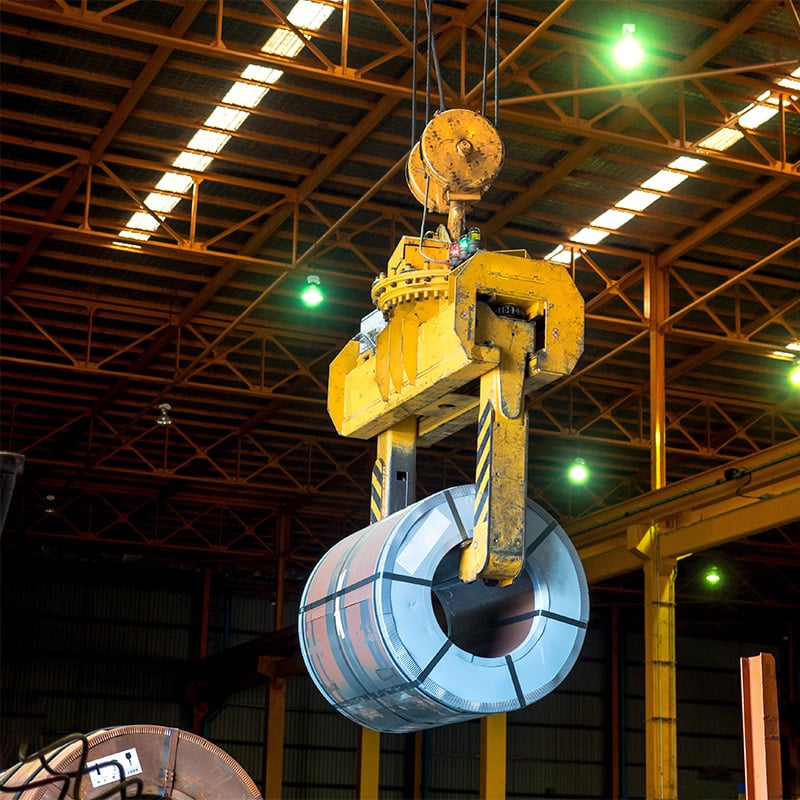 An overhead crane -Coil tong carrying a steel coil